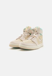 Sneakers beige alta con tomaia in suede e tessuto, dotate di accenti turchesi, punta perforata e suola in gomma bianca.