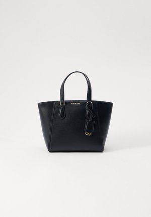 Czarna skórzana torba typu tote Michael Kors z podwójnymi uchwytami i przymocowanym brelokiem na białym tle.