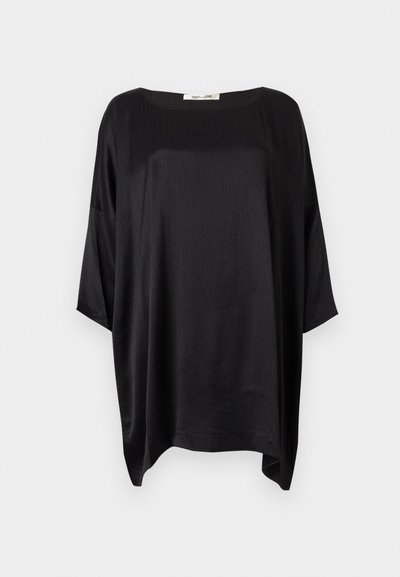 Raširena crna satenska bluza sa širokim okruglim izrezom i rukavima do tri četvrtine na jednobojnoj pozadini.