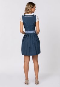 Blaues Kleid mit tailliertem Oberteil, weißen Spitzenärmeln und gefälteltem Rock. Es hat ein satinbeschichtetes Taillenband und ein kleines Punktemuster.