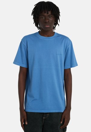 Krótki rękaw T-shirt z jasnoniebieskiej bawełny. Standardowy krój z okrągłym dekoltem. Małe logo na piersi. Połączony z czarnymi teksturowanymi szortami.