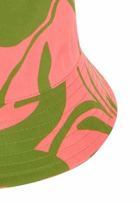 Cappello a secchiello in tessuto, con uno sfondo rosa e motivi astratti verdi. Texture liscia con dettagli cuciti lungo il bordo.
