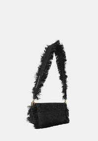 Borsa nera con una tracolla frangiata e testurizzata, caratterizzata da un corpo rettangolare, un top decorato e dettagli in hardware dorato.