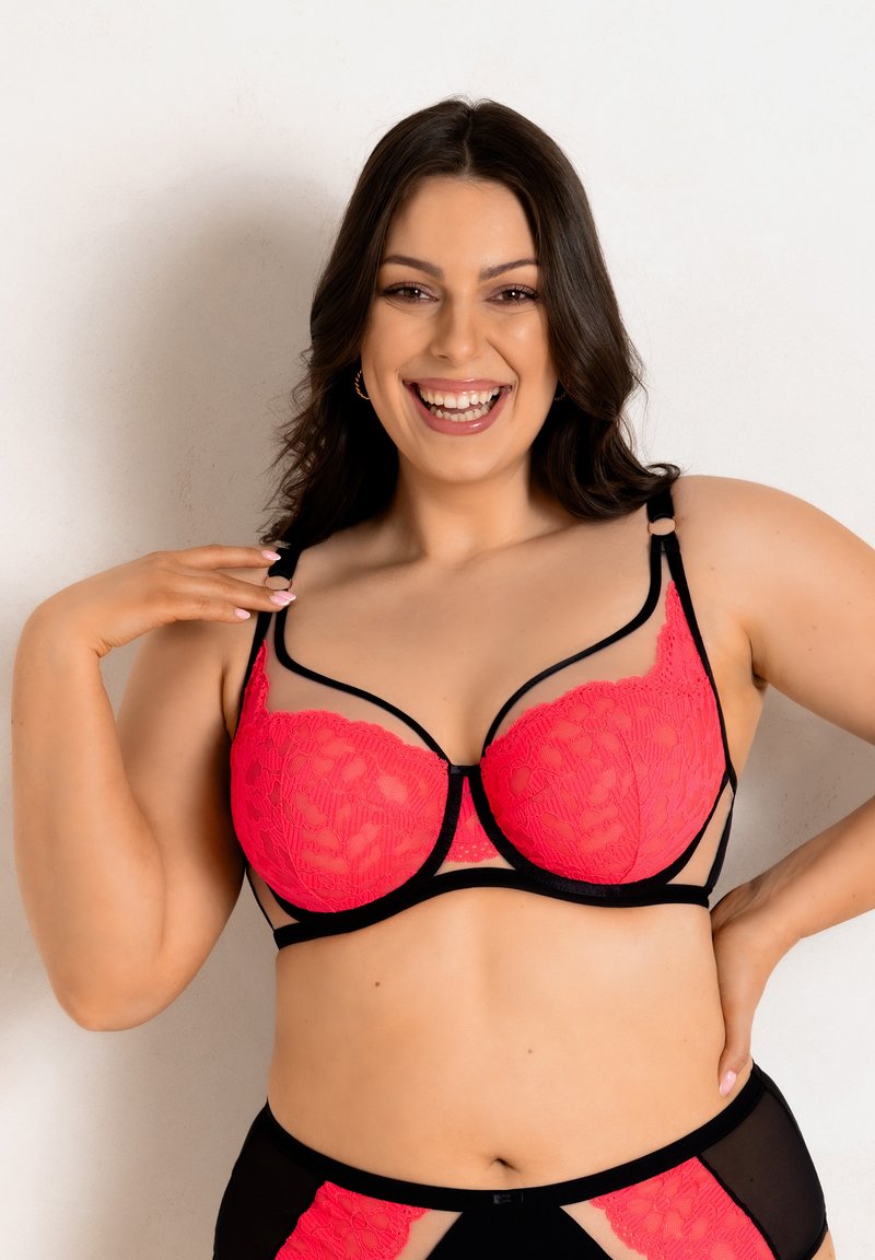 Koronkowy stanik w intensywnym różowym kolorze z czarnymi akcentami. Posiada usztywnioną konstrukcję z siateczkowymi detalami oraz regulowane ramiączka dla lepszego dopasowania.