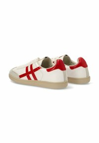 Zapatillas blancas con acentos y rayas rojas, con una suela texturizada en beige y detalles de ante suave cerca del dedo del pie. Diseño simple de cordones.