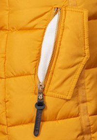 Yellow puffer jacket fabric with quilted pattern, featuring a gold metal zipper and a plush white lining inside the pocket.