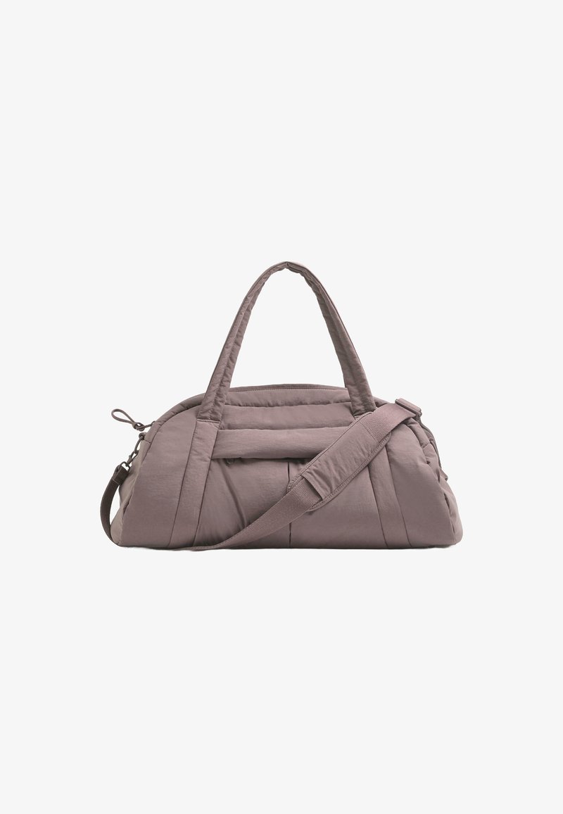 Sac de sport matelassé en mauve doux, doté de doubles poignées et d'une sangle amovible. Comprend une poche avant avec fermeture à bouton et des lignes épurées.