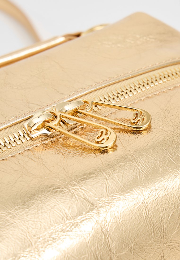 Gouden metallic clutch met een gestructureerde afwerking, dubbele ritsen en een gladde band, die een slank en modern ontwerp benadrukt.