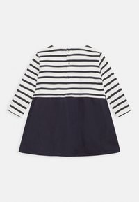Vestido de mangas largas con rayas horizontales en navy y blanco en la parte superior y una parte inferior sólida en navy, con un cierre de botón en la parte posterior.