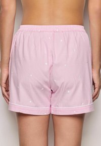 Roze katoenen shorts met witte stippen en een gestreepte structuur. Kenmerkend zijn de elastische tailleband en de afwerking van de zoom.