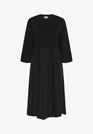 Robe noire avec un col rond et des manches trois-quarts. Dispose d'un corsage ajusté et d'une jupe froncée pour une silhouette décontractée. Tissu doux.