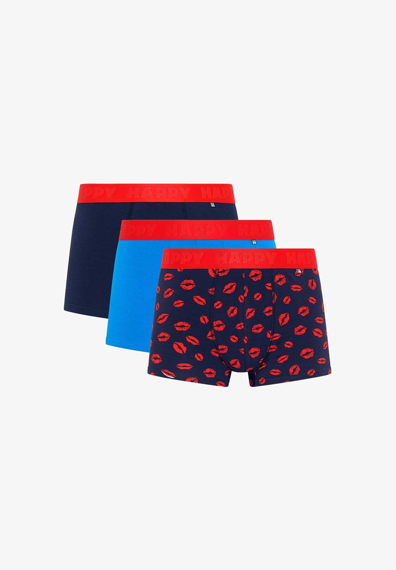 Três pares de boxers masculinos com cós vermelho; um azul-marinho com impressões de lábios vermelhos, um azul sólido e um azul-marinho sólido.