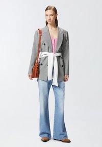 Sivi karirani dvostruko zatvoreni sako, bijeli pojas, ružičasta košulja na kopčanje, svijetloplave traperice širokih nogavica, smešne cipele za klizanje, smešasta torbica preko tijela.