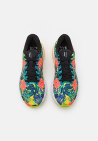 Scarpe da corsa multicolori con motivo floreale in rosa, verde e blu, una tomaia in mesh nera e una suola intermedia bianca.