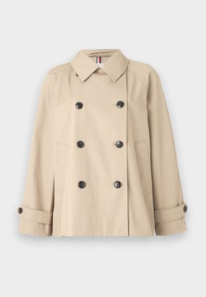 Cappotto trench beige con bottoni doppi, accessori neri, colletto ampio e tasche laterali. Presenta maniche con polsini e una superficie liscia.