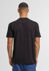Zwarte katoenen t-shirt met ronde halslijn, korte mouwen en een comfortabele pasvorm. Effen textuur, zonder patronen of accenten zichtbaar.