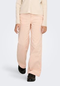 Light pink wide-leg pants with a smooth texture, paired with a cream ribbed sweater and black loafers. Simple and modern design.