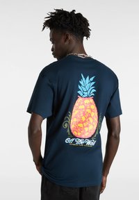 Granatowa koszulka z dużym, stylizowanym motywem ananasa w żółtym i niebieskim kolorze, z misternymi wzorami czaszek i logo "Off The Wall".