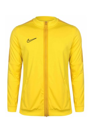 Gelbe Nike-Sportjacke mit durchgehendem Frontreißverschluss, langen Ärmeln und schwarzem Nike-Swoosh auf der linken Brust.