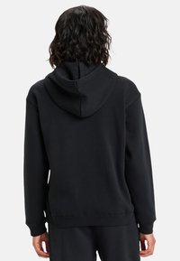 Sudadera con capucha negra, de textura suave, con puños y bajo acanalados, que presenta un diseño simple y funcional sin logotipos ni adornos.