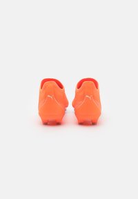 Scarpe da calcio arancione brillante con una finitura testurizzata, una vestibilità aderente e branding bianco. Presentano un design a profilo basso e tacchetti stampati.