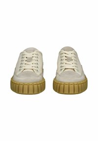 Weiße Wildledersneaker mit cremefarbenen Schnürsenkeln, abgerundeter Zehenpartie und strukturierter, brauner Gummisohle mit vertikalen Rillen. Keine auffällige Markenkennzeichnung sichtbar.