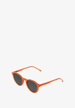 Lunettes de soleil à monture ronde avec des bords en plastique translucide orange et des verres teintés sombres, vue en angle sur fond blanc.