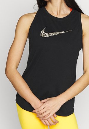 Černý bezrukávový sportovní top s leopardím potiskem loga Nike. Má kulatý výstřih a volný střih. Spárován se žlutými legínami.