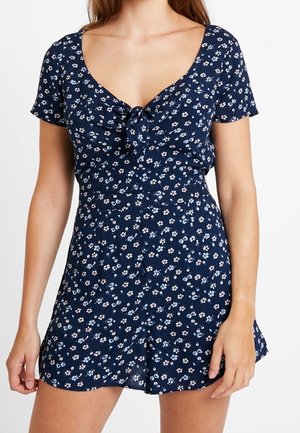 Marineblaues Blumenkleid mit kurzen Ärmeln, Rundhalsausschnitt und Frontbindedetail. Es hat kleine weiße und hellblaue Blumenmuster.