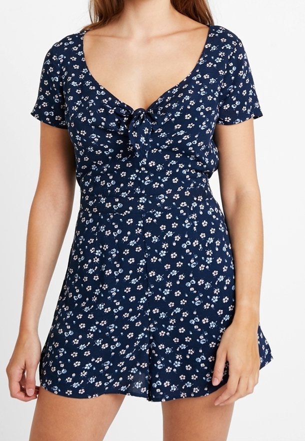 Námořnické květinové šaty s krátkými rukávy, kulatým výstřihem a předním zavazováním. Obsahují malé bílé a světle modré květinové vzory.