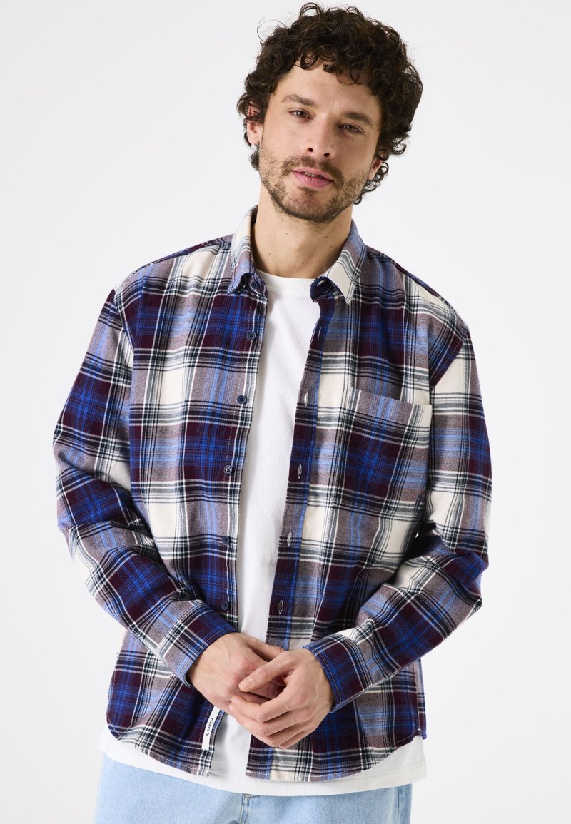 Gekleed overhemd met een ruitpatroon in blauw, wit en bordeauxrood, lange mouwen, een button-down kraag en een borstzak. Katoenen stof met een zachte textuur.