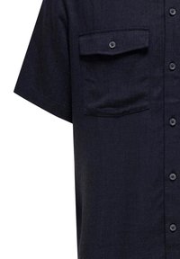 Kurzarm-Dunkelblaues Hemd mit Knöpfen aus strukturiertem Stoff, einem einzelnen Brusttasche und fünf runden Knöpfen auf der Vorderseite.