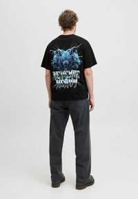 Black cotton T-shirt featuring a blue wolf graphic with lightning accents and "REVENGE IS SWEET" text on the back. Relaxed fit, crew neck.