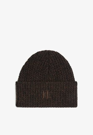 Beanie lavorato a maglia di colore marrone scuro con una trama testurizzata. Presenta un risvolto e un logo in rilievo sul davanti. Misura circa 25 centimetri di altezza.