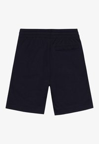 Shorts blu scuro con elastico in vita e una singola tasca posteriore sul lato destro, mostrati da dietro su uno sfondo bianco.