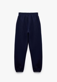 Mørkeblå sweatsbukser lavet af blødt stof, med en elastisk talje og cuffs, i et afslappet snit uden synlige mønstre eller accenter.