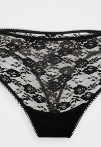 Schwarze Spitzenunterwäsche für Frauen mit floralem Muster und Wellenkante auf weißem Hintergrund.