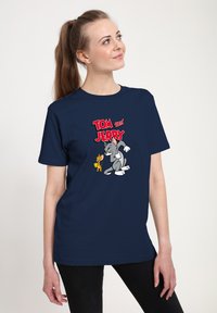 Marineblaue Kurzarm-T-Shirt aus Baumwolle, mit einem grafischen Druck von Tom und Jerry in lebhaften Farben und einer glatten Textur.