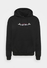 Sudadera negra con bolsillo delantero, capucha con cordón y diseño gráfico que presenta pájaros blancos y el texto "Light Addict". Textura de tela suave.