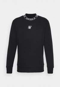 Svart långärmad sweatshirt med ribbstickade ärmmuddar och nederkant, vit broderad logotyp på bröstet och märkesnamnet "SIKSILK" runt kragen.