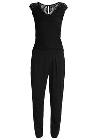 Combinaison noire avec des manches en dentelle, décolleté en V avec un détail en trou de serrure, taille froncée et pantalon fuselé.