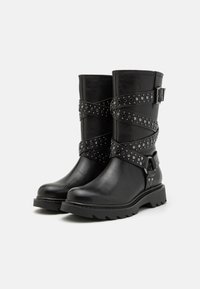 Black leather boots with a rounded toe, mid-calf height, featuring crisscross straps with silver studs and a decorative buckle accent.