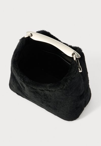 Bolso de mano de piel sintética negra con una textura suave, forma rectangular y un asa plateada brillante. El interior es completamente negro sin compartimentos visibles.