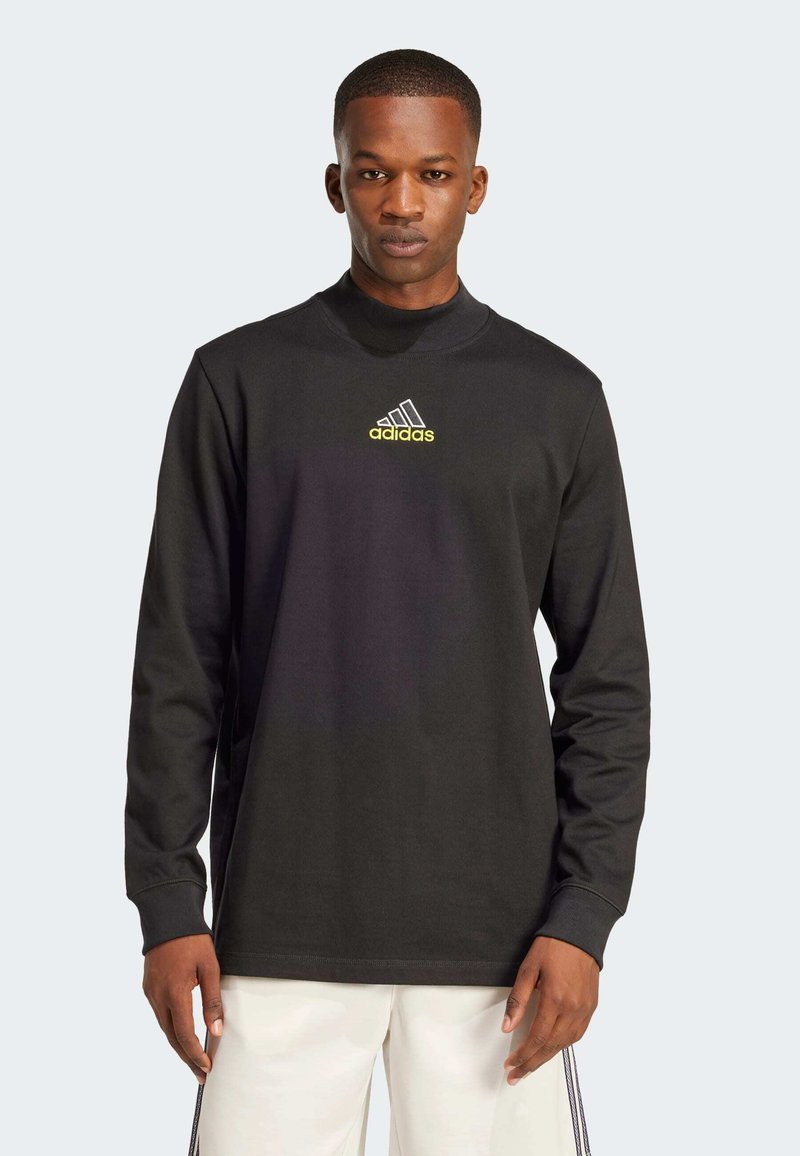 Svart langermet skjorte laget av bomull, med høy hals, Adidas-logo i gult, og en avslappet passform. Enkel design uten mønstre.