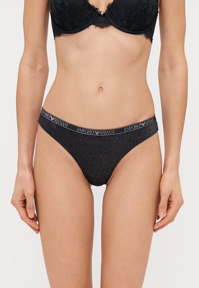 Perizoma nero con una texture glitterata e un elastico con il logo "Emporio Armani". Design minimalista con un taglio a vita bassa.