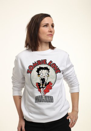 Biała sweatshirt z graficznym wizerunkiem postaci w tematyce zombie, z czerwonymi akcentami, otoczona napisem "ZOMBIE LOVE". Miękki materiał, luźny krój.