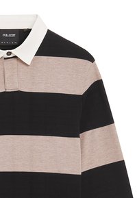 Schwarz-beige gestreiftes Polohemd mit einem weißen Kragen, das über eine Knopfleiste mit zwei Knöpfen und ein strukturiertes Gewebe verfügt. Branding im Inneren des Kragens sichtbar.