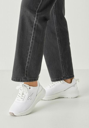 Białe sportowe sneakersy z siateczkową cholewką, sznurowane, z fakturowaną podeszwą. Ozdobione szarymi detalami. W połączeniu z ciemnymi dżinsami.