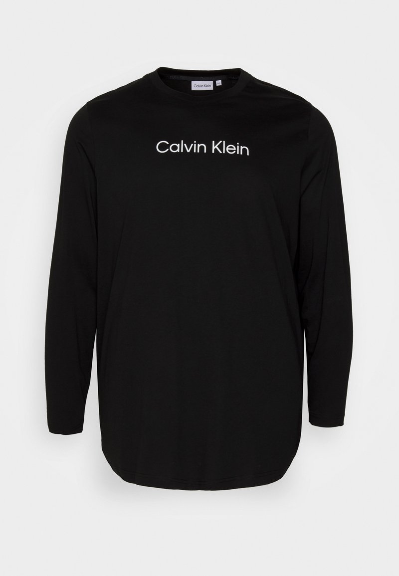T-shirt preto de manga longa feito de um tecido suave com decote redondo. Apresenta o logótipo branco "Calvin Klein" em destaque no peito. Design simples.