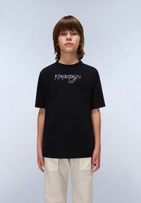 Svart t-shirt med kort ärm som har en reflekterande "Napapijri 1987" logotyp på framsidan. Tillverkad av bomull, har den en avslappnad passform och rund halsringning.
